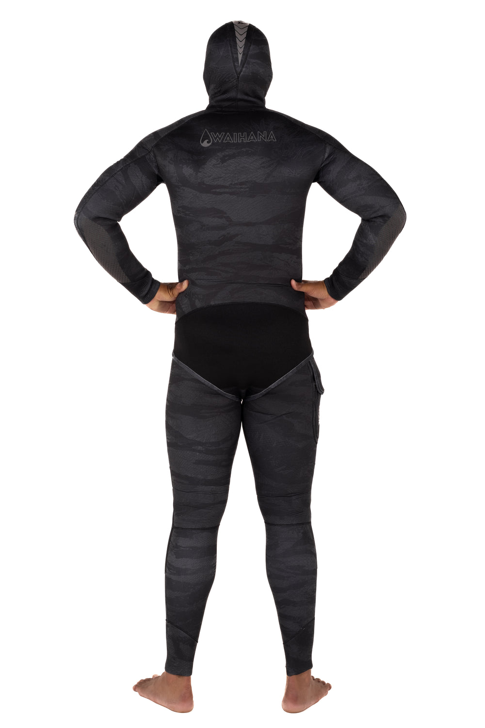 Rear view of a man wearing the Waihana Men's Tropicam Black 3.5mm hooded wetsuit top and pants, featuring dark camouflage neoprene patterning and the Waihana logo on the upper back.